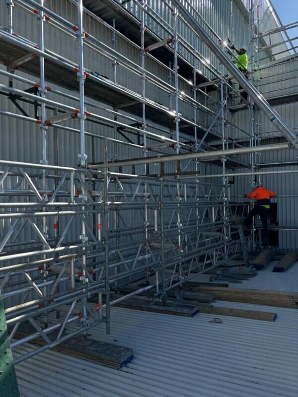 Aluminium mobile tower in use inside an industrial warehouse